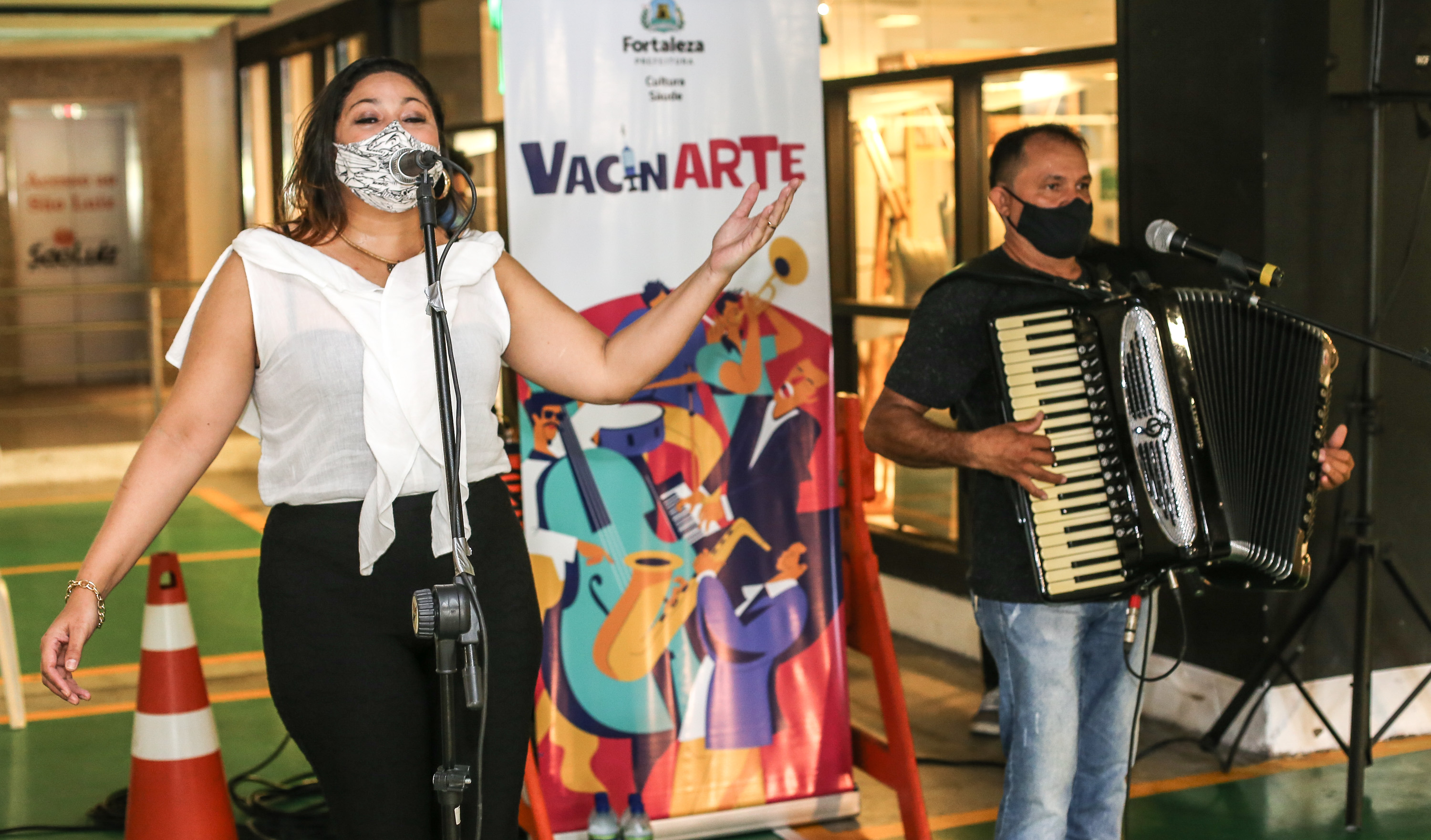 uma mulher canta e um homem toca sanfona